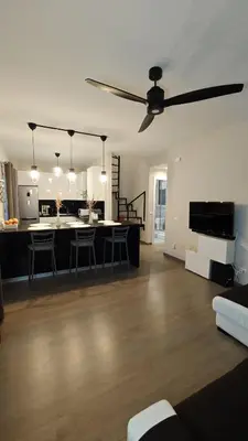 a large living room with a ceiling fan and a kitchen at Profumo di casa 2 in Lascari