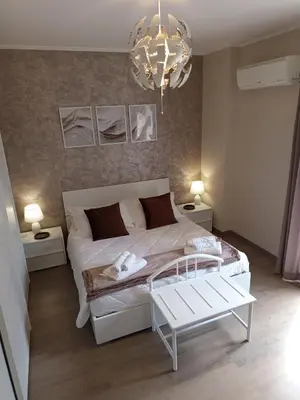 a bedroom with a white bed and a chandelier at Profumo di casa 2 in Lascari
