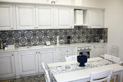 a kitchen with white cabinets and a table with a vase on it at Sapphire Home in Palermo