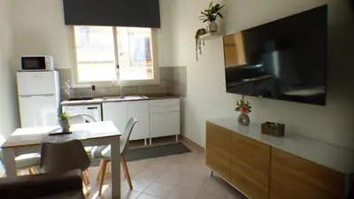 a kitchen with a table and a kitchen with a television at Apollo Apartment in Palermo