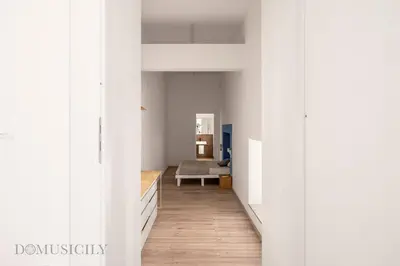 a hallway with white walls and a couch in a room at Loggiato dei Ventimiglia By DomuSicily in Palermo