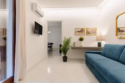 a living room with a blue couch and a tv at Dimora d'incanto al Capo in Palermo