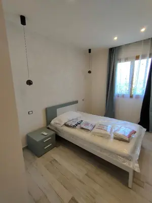 a bedroom with a bed with a night stand and a window at Brezza Marina in Alcamo