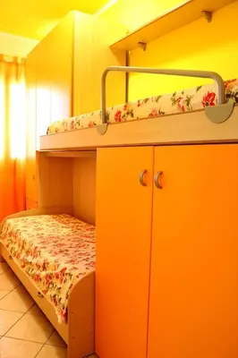 two bunk beds in a room with an orange room at Villetta Gelsomini, San Vito Lo Capo in San Vito lo Capo