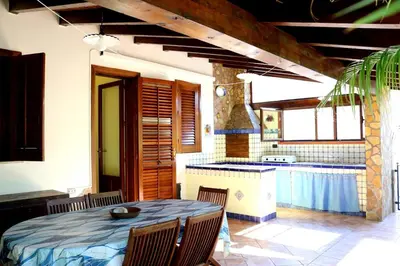 a kitchen and dining room with a table and chairs at Villetta Gelsomini, San Vito Lo Capo in San Vito lo Capo