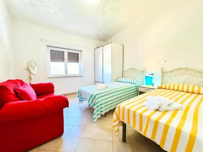 a living room with two beds and a red couch at Villa Donna Vincenza