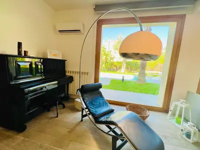 a living room with a chair and a piano at Villa Donna Vincenza