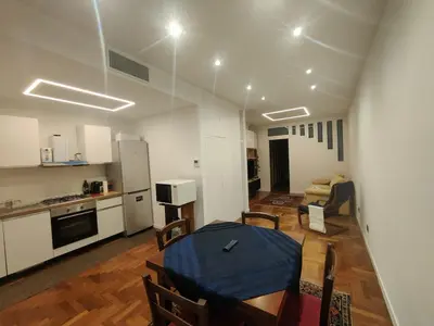 a kitchen and a living room with a table and chairs at Susy's home in Palermo