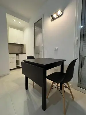 a black table and a chair in a kitchen at Cala38 in Terrasini