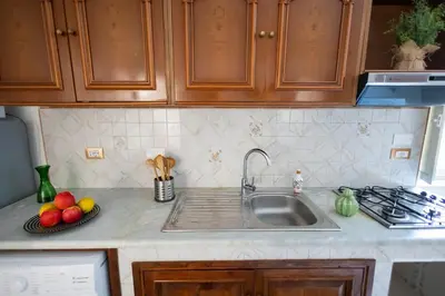 a kitchen counter with a sink and fruits on a plate at iFlat Casa Sant'Agata in Palermo