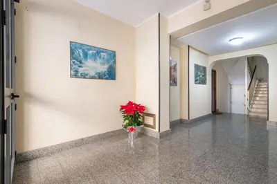 a hallway with a vase with red flowers in it at GuestHost - Lovely Flat near Palazzo dei Normanni in Palermo