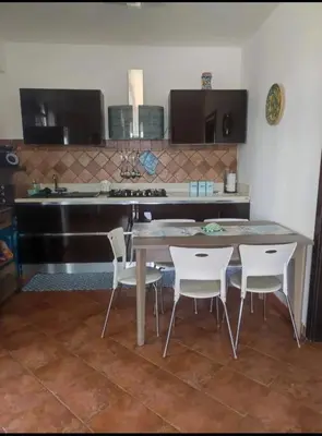 a kitchen with a table and chairs and a stove at La terrazza vent8 in Buonfornello