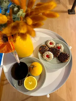 a white table with two plates of food and a vase with flowers at Casa del Teatro in Palermo