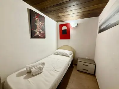 a small room with two beds and a painting at Casa del Cortile Secco in Palermo