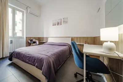 a bedroom with a bed and a desk and a chair at La Casetta di Simo & Leo in Palermo