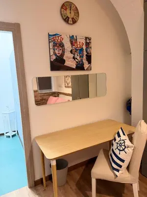 a dining room with a wooden table and a clock at Come A To Casa in Aspra