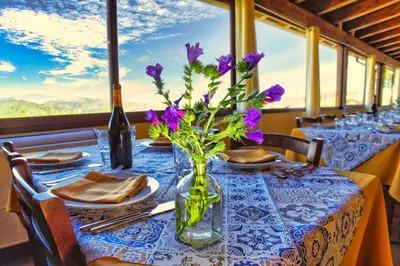a table with purple flowers in a vase at Agriturismo Case Varisco in Altavilla Milicia