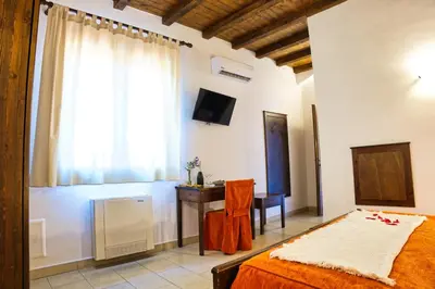 a bedroom with a bed and a desk and a window at Agriturismo Case Varisco in Altavilla Milicia