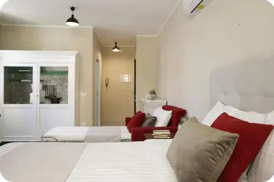 a bedroom with two beds and a red chair at La Luna di Noah al Massimo in Palermo