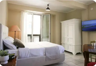 a bedroom with a white bed and a large window at La Luna di Noah al Massimo in Palermo