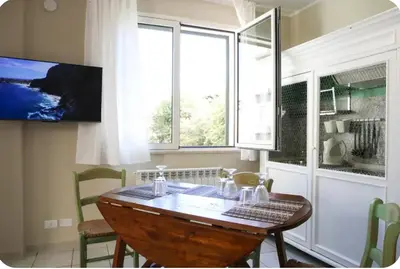 a dining room with a wooden table and a window at La Luna di Noah al Massimo in Palermo