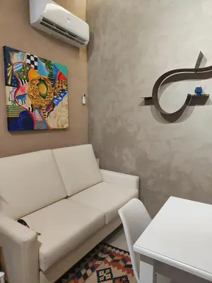 a living room with a white couch and a painting at Venticinque Passi - nel cuore di Palermo in Palermo