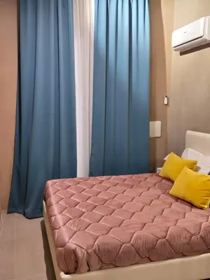 a bedroom with a large bed with blue curtains at Venticinque Passi - nel cuore di Palermo in Palermo