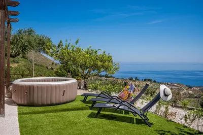 a couple of chairs sitting on the grass next to a fire pit at Vista Mare Scopello AC Jacuzzi 3 camere by Proger in Scopello