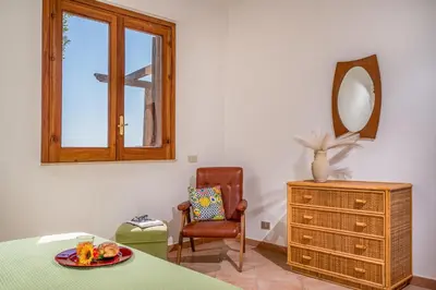 a room with a table and a mirror and a chair at Vista Mare Scopello AC Jacuzzi 3 camere by Proger in Scopello