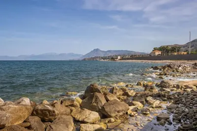 a group of rocks on a beach near the water at Richgood Luxury homes - Villa Zefira sole in Altavilla Milicia