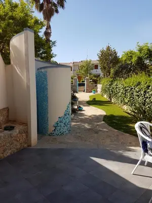 a patio with a chair and a wall at Villa La Chiocciola in San Vito lo Capo