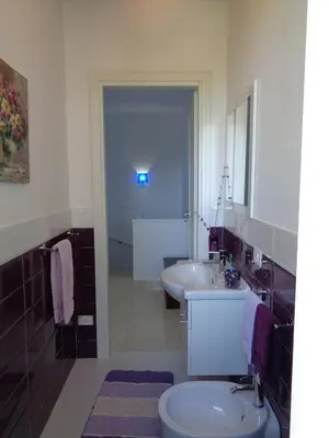 a bathroom with a sink and a toilet and a mirror at Villa La Chiocciola in San Vito lo Capo