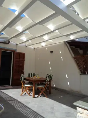 a table and chairs in a room with a ceiling at Villa La Chiocciola in San Vito lo Capo