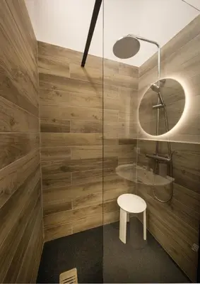 a bathroom with a shower with a stool and a mirror at Bonsai Loft in Palermo