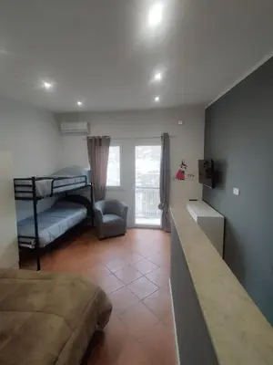 a bedroom with a bunk bed and a living room at Mumin in Carini