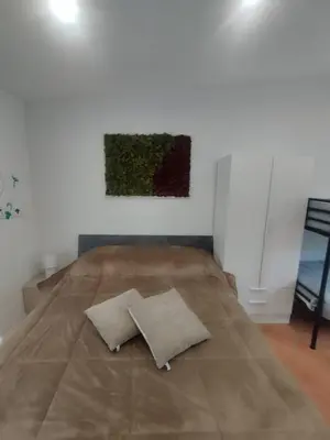 a bed in a room with a painting on the wall at Mumin in Carini