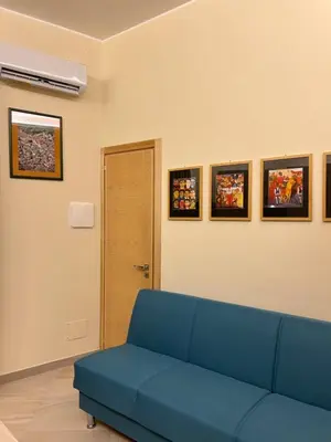 a blue couch in a room with pictures on the wall at Tra chiazza e casteddu in Mezzojuso