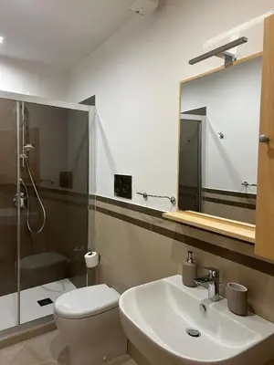 a bathroom with a sink and a toilet and a mirror at Tra chiazza e casteddu in Mezzojuso