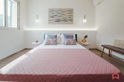 a bedroom with a large bed with a pink comforter at Deliziosa Villa con Piscina e Jacuzzi a Scopello in Castellammare del Golfo