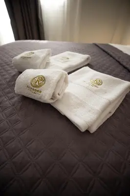 four white towels are sitting on a bed at Richgood Luxury homes - Villa Zefira mare in Altavilla Milicia