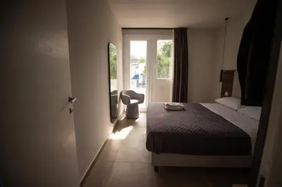 a bedroom with a bed and a door with a window at Richgood Luxury homes - Villa Zefira mare in Altavilla Milicia