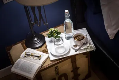a table with a plate and a bottle and a book at Suite 136 in Palermo