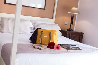a yellow bag sitting on top of a bed at Suite 136 in Palermo