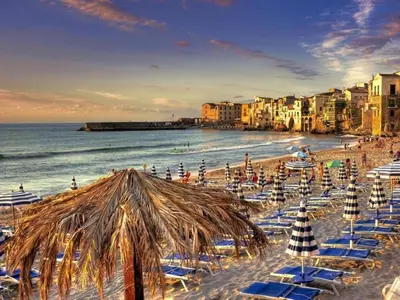 a beach with chairs and umbrellas and the ocean at Holiday Home Villa mit Wasserblick by Interhome in Cefalù