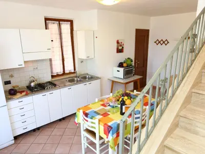 a kitchen with white cabinets and a table with a tablecloth at Holiday Home Helle mediterrane Villa mit Veranda und Garten by Interhome in Cefalù