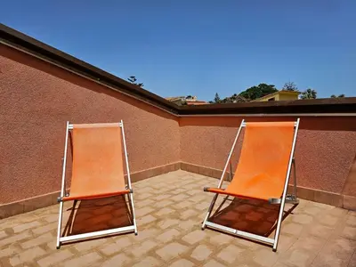 two orange chairs sitting on top of a building at Holiday Home Helle mediterrane Villa mit Veranda und Garten by Interhome in Cefalù
