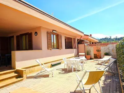 a patio with chairs and a table on a house at Holiday Home Helle mediterrane Villa mit Veranda und Garten by Interhome in Cefalù