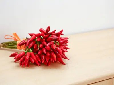 a bunch of red chili peppers on a cutting board at Holiday Home Helle mediterrane Villa mit Veranda und Garten by Interhome in Cefalù