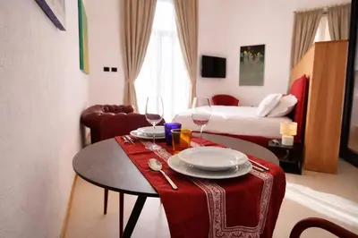 a table with two wine glasses and plates on it at Dimora Monteleone in Palermo