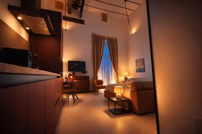 a bedroom with a bed and a living room at Dimora Monteleone in Palermo